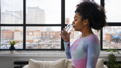 A Woman Drinking A Glass Of Water To Refresh Herself