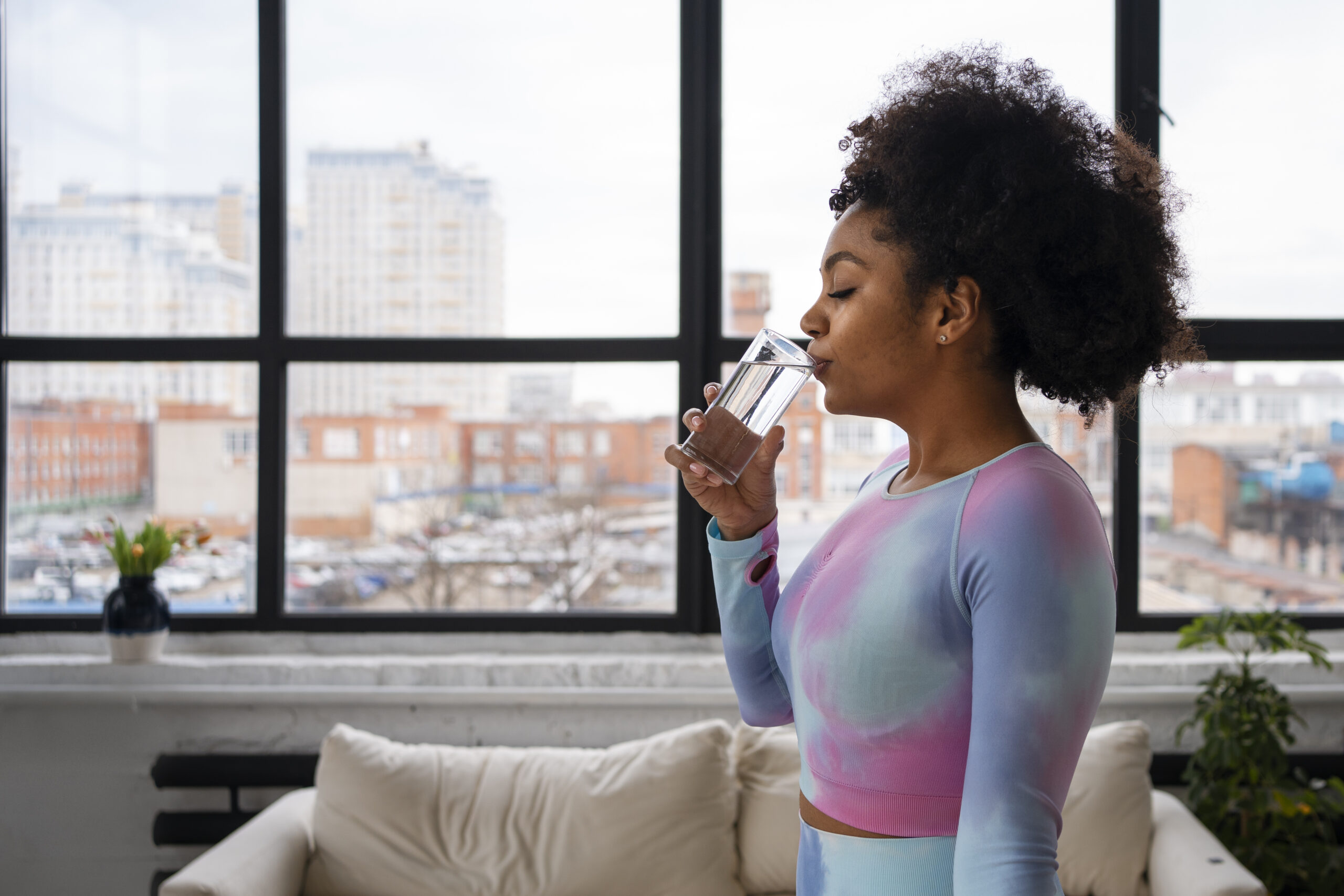 A Woman Drinking A Glass Of Water To Refresh Herself