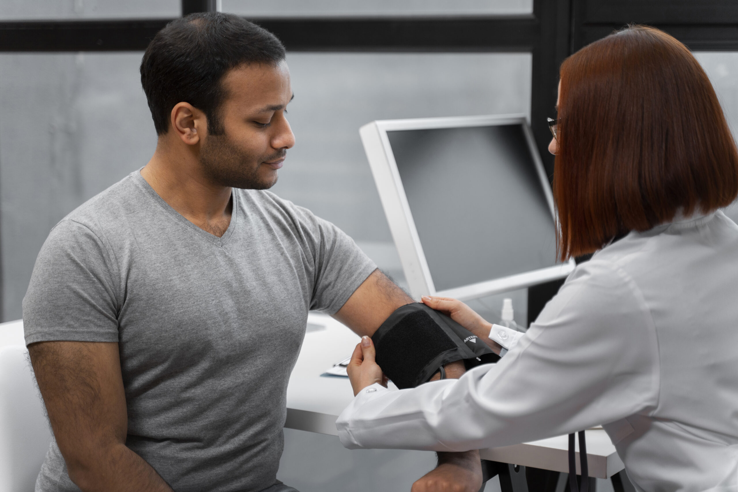 Side view of a female doctor seen, testing her patient blood pressure level