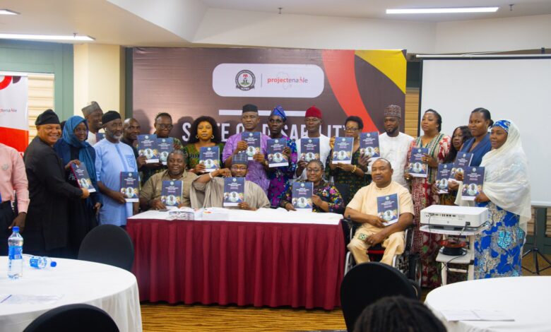 Group photo of disability advocates and government officials during report presentation.