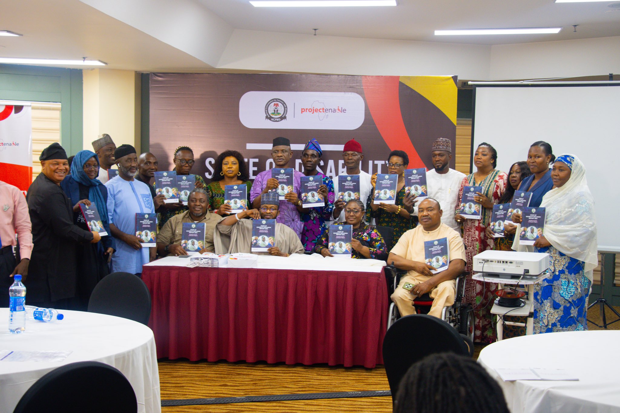 Group photo of disability advocates and government officials during report presentation.